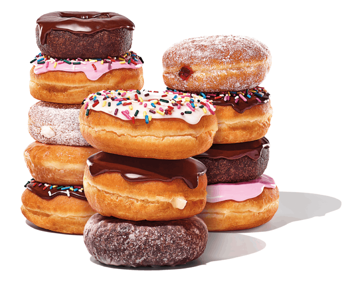 A stack of various donuts, including chocolate glazed, powdered, and sprinkle-covered, arranged in two piles, awaits you at your favorite coffee and donuts franchise.